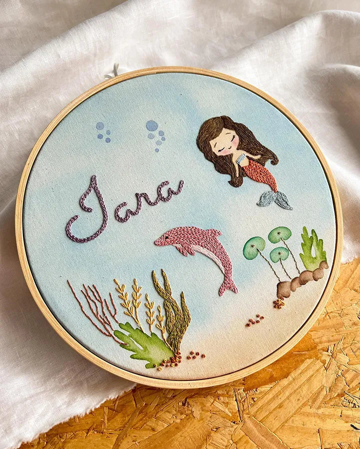 Custom mermaid nursery decor showing detailed baby mermaid embroidery work
