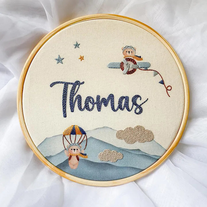 Embroidery hoop with embroidered design of a child in a hot air balloon and the name