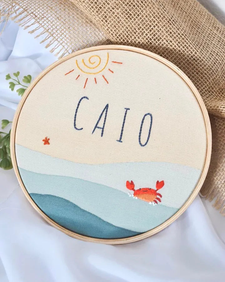 Embroidery hoop with name, sun and crab.