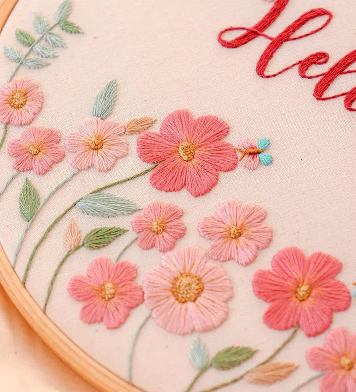 Embroidery hoop with pink flowers and green leaves