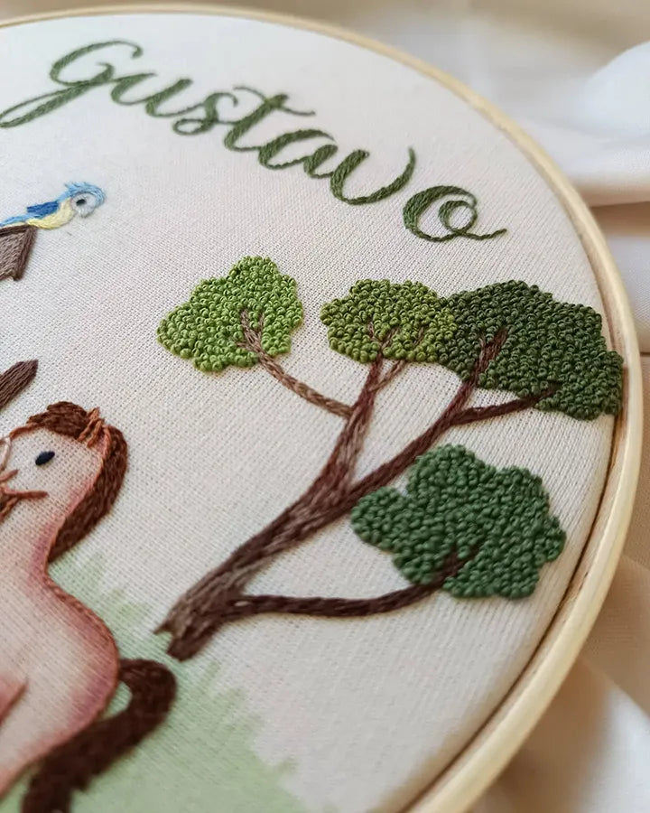 Hand stitched farmhouse clock showing detailed barn and animal needlework