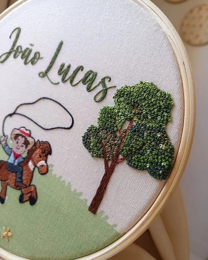 Embroidery hoop with a cowboy and tree design, featuring the name
