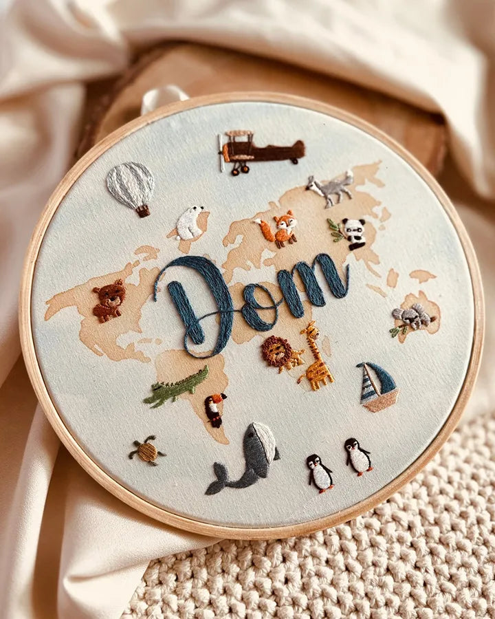 Personalized nursery clock with hand-embroidered world map design