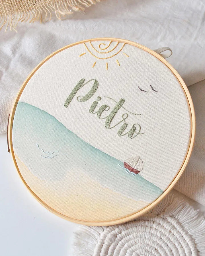 Decorative hoop with name  and sailboat pattern on a light background