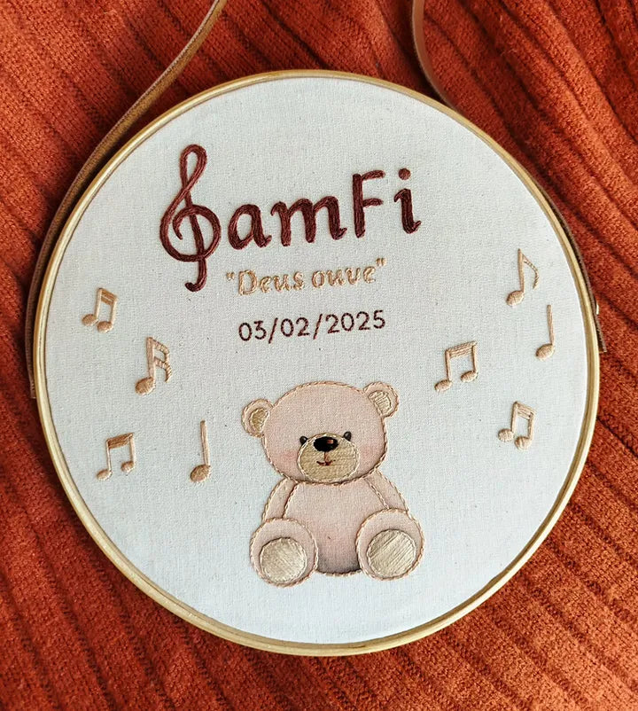 embroidered hoop design with a teddy bear, musical notes and baby name